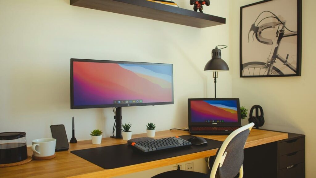 Mesa de trabalho organizada com computador e notebook para praticar técnicas de memorização