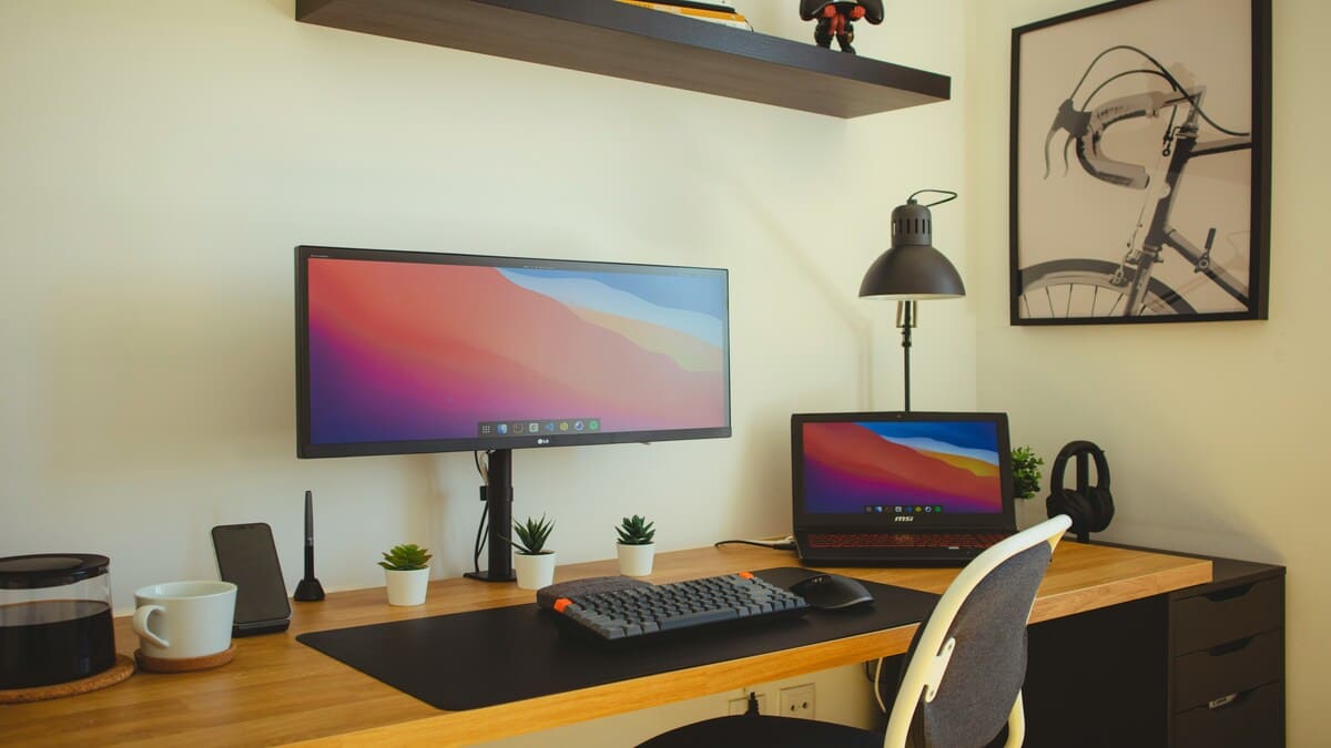 Mesa de trabalho organizada com computador e notebook para praticar técnicas de memorização